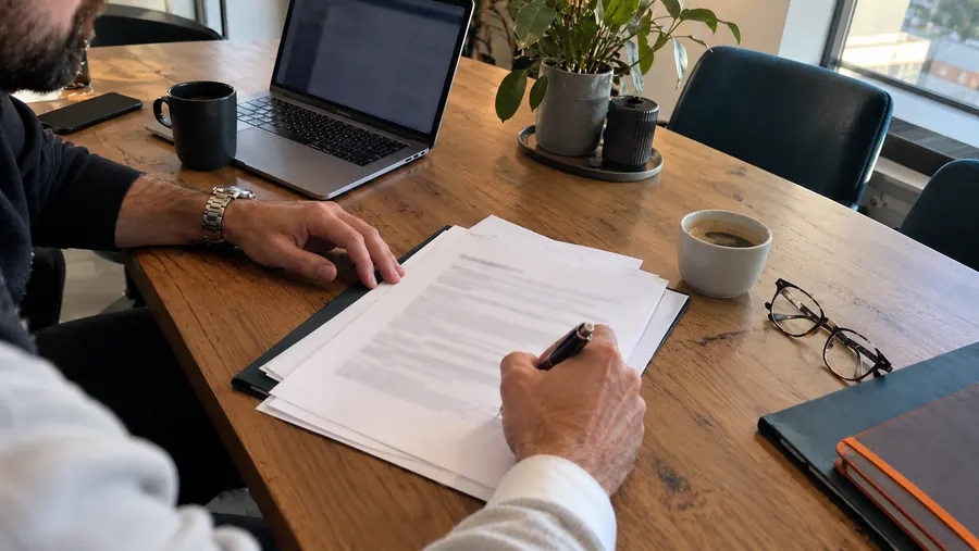 Unterschrift unter einen Vertrag am Besprechungstisch